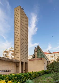 An exterior view of the Neo-Gothic style Church of the Immaculate Conception in Baku, Azerbaijan, featuring a tall tower and a statue of the Virgin Mary