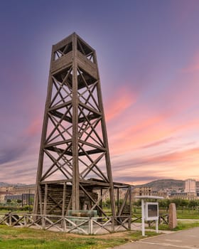 Worlds first industrially drilled oil well in Baku, Azerbaijan. The wooden structure stands tall against a vibrant sunset sky