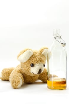 Teddy bear with a bottle of alcohol on a white background