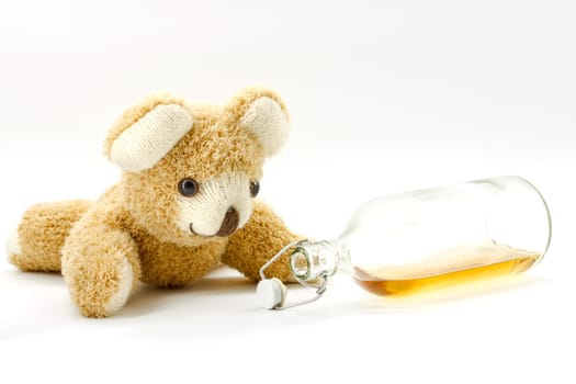 Teddy bear with a bottle of alcohol on a white background