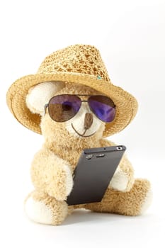 Teddy bear with glasses and smartphone on white background