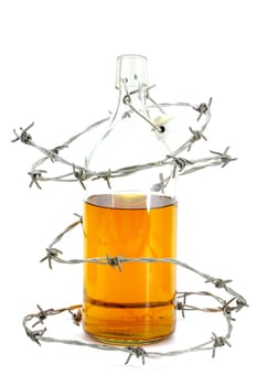 Barbed wire around a glass bottle of alcohol on a white background