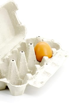 Egg in cardboard box made from recycled paper on a white background