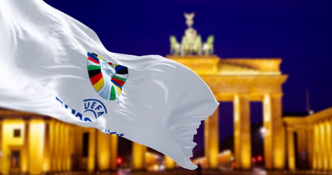 Berlin, Ger, May 15 2024: Flag of UEFA Euro 2024 waving with blurred Brandenburg Gate in the background . Selective focus. Illustrative editorial 3d illustration render. International sport event