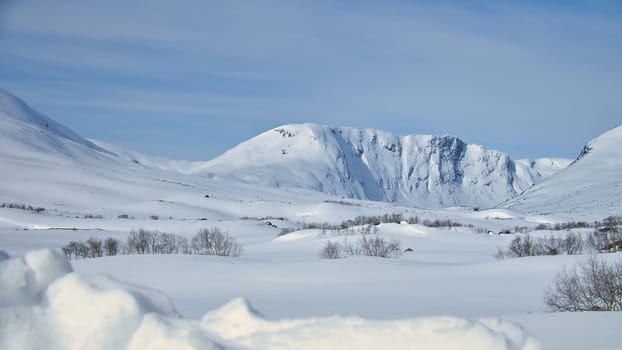Norwegian high mountains in the snow. Mountains covered in snow. Scandinavian landscape in the far north