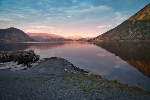 Norwegian landscape. View over a small harbor to the fjord at sunset behind the mountain. Scandinavian nature