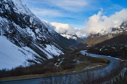 Norwegian landscape. The road leads through a mountain gorge that descends from the glacier. Rough nature in Scandinavia. Landscape photo from the north