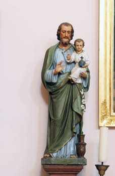 Saint Joseph holds the child Jesus, statue at the altar of Saint Anne in the parish church of Wounded Jesus in Gradec, Croatia