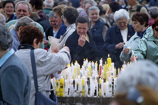 Women light candles in front of the Basilica of the Assumption of the Virgin Mary in Marija Bistrica, Croatia