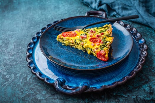 Homemade frittata with spinach, curd cheese, bacon, onion and green onions