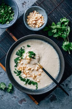 Spicy and creamy cauliflower and coconut soup with cilantro and macadamia nuts