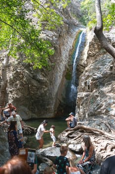 Troodos Mountains, Cyprus - September 09, 2023: Visitors enjoy a day by a serene natural Millomeris waterfall in a lush forest setting