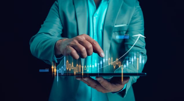 Businessman or trader is touching showing  a growing virtual hologram stock on tablet, business planning and strategy, Stock market, Business growth, progress or success concept. Invest in trading.