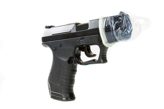 Condoms placed on a gun on a white background