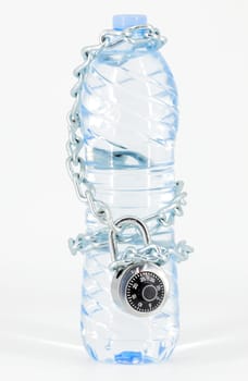 Bottle of mineral water locked with chain and padlock on white background