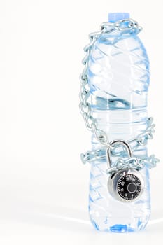 Bottle of mineral water locked with chain and padlock on white background