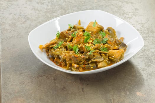 Stew of pork and vegetables served in a white porcelain dish