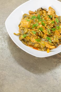 Stew of pork and vegetables served in a white porcelain dish