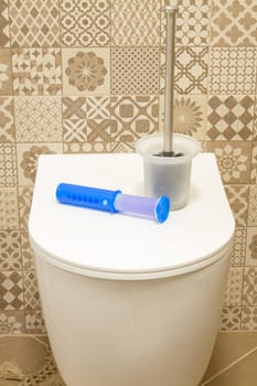 Modern toilet bowl with blue detergent for cleaning and disinfection