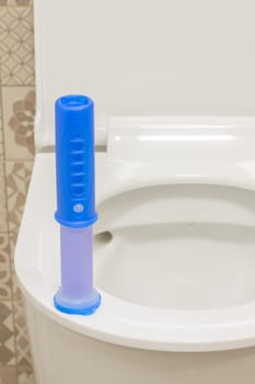 Modern toilet bowl with blue detergent for cleaning and disinfection