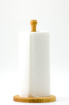 Roll kitchen paper on a wooden stand on a white background