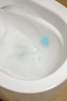 Modern toilet bowl with blue detergent for cleaning and disinfection