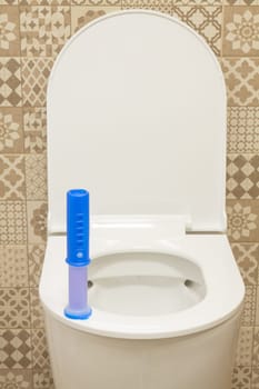 Modern toilet bowl with blue detergent for cleaning and disinfection