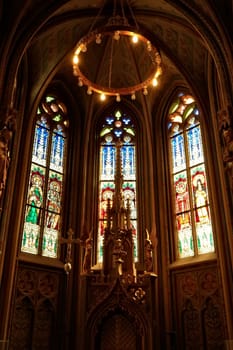 Little altar in front of colorful stained glass windows in gothic style shape inside the Matthias Church, Budapest, Hungary 2022