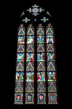 Colorful stained glass window in a gothic style shape inside the Matthias Church at the Holy Trinity Square in Budapest, Hungary 2022