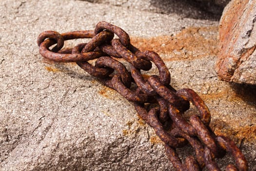 Old rusty chain stapled stone wall