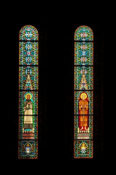 Two colorful stained glass windows inside the Matthias Church at the Holy Trinity Square in Budapest, Hungary 2022