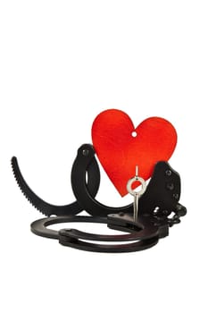 Black oxide handcuffs and red wooden heart on a white background