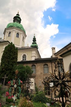 Crosses of graves in front of the St. Peter's Abbey Church, Stiftskirche Sankt Peter and the Mariazell Chapel, Mariazeller Kapelle at the St., Saint Peter's Cemetery, Petersfriedhof, Salzburg, Austria 2022
