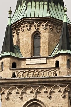 The upper facade of the bell, clock tower of the Franciscan Church, Franziskanerkirche in Salzburg, Austria 2022