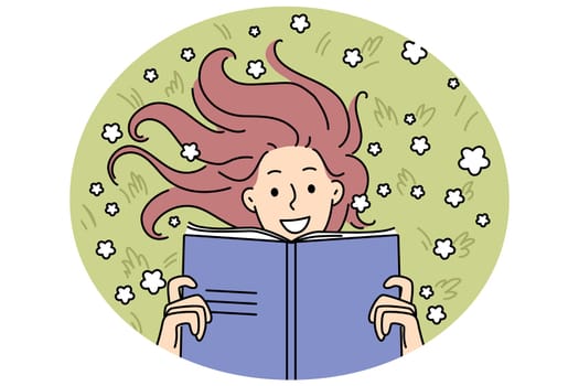 Woman with book lies on meadow reading favorite novel and enjoying onset of summer days. Happy girl with smile rests on meadow with flowers and holds textbook to prepare for entrance exams