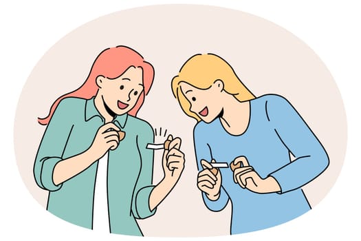 Happy girls hold fortune cookies and laugh as rejoice at cheerful wishes found inside pastry. Young women in casual clothes are intrigued reading messages hidden in cookies with wishes.