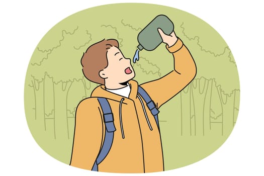 Man drinks water hiking in forest feeling thirsty after long walk through wilderness area with trees. Young guy with flask is fond of hiking and travels in national nature reserve.