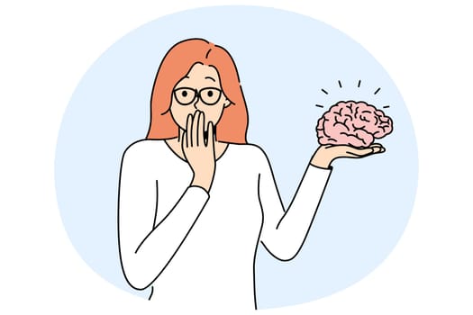 Woman with brain in hand looks at screen for concept of psychological therapy and intellectual development. Girl holds brain advertising services of psychologist or specialist in medical neurology