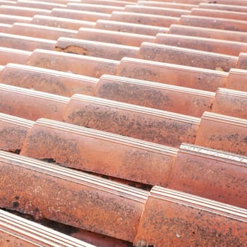 Old tiled roof. Close up of the red clay roof tiles. Background of old roof.