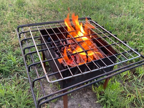 The barbecue grill is burning for frying shashlik on the coals