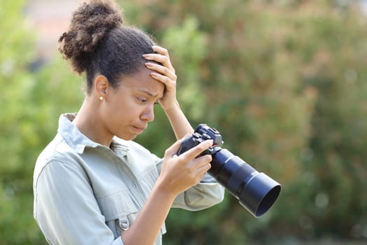 Profile of a frustrated black photographer checking result on camera
