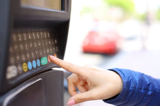 Close up portrait of a woman hand using parking meter in the street