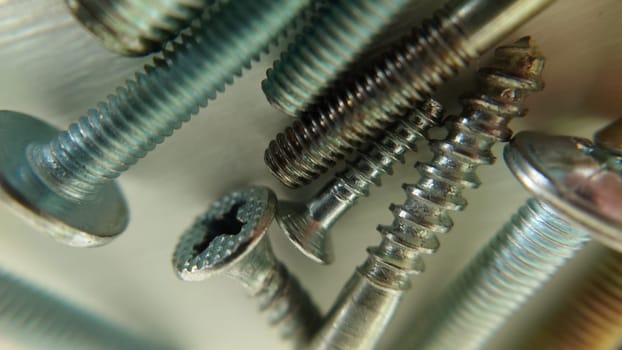 Screws bolts of different sizes are on the table. Macrophotography.Texture or background.Selective focus.
