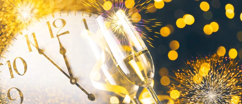 New year eve celebration with champagne flutes and midnight countdown  on golden firework bokeh background. Christmas party with blur confetti glitter, classy drink and vintage clock.