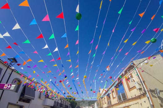 Spanish little town garland with colorful pennants. Two storey houses background
