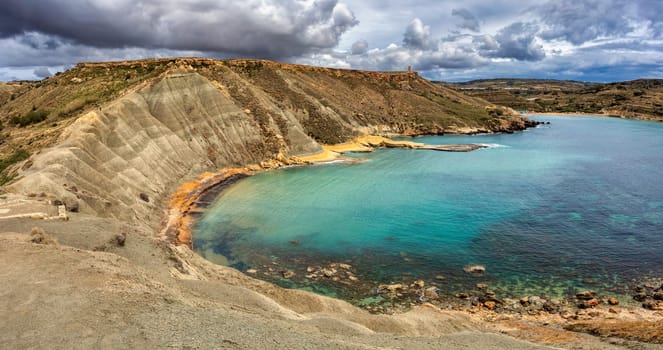 Il-Qarraba, stunning privileged viewpoint over both Riviera Bay locally known as Ghajn Tuffieha Bay and Qarraba Bay with red sand. Malta