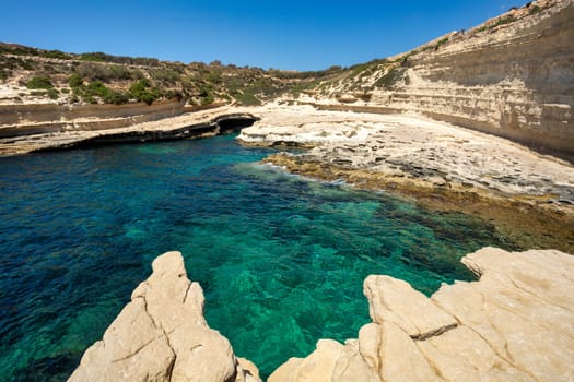 Saint Peter's Pool, beautiful coastal view of Delimara peninsula, with rocks and turquoise sea, Island Malta natural landscape.