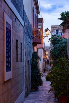 Narrow, winding alleyway in Vittoriosa - Birgu ancient core reveals historic sandstone facades and glimpses of Malta's storied past. Cultural heritage of Malta