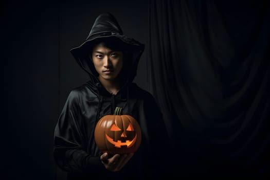 A person in a witch costume holds a glowing jackolantern in a dark setting, symbolizing Halloween