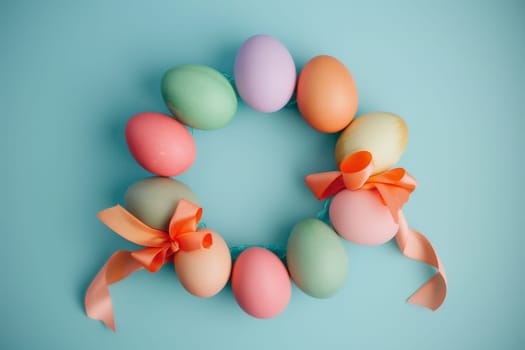 Pastel-colored Easter eggs arranged in a wreath with ribbon accents